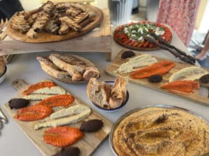 Buffet garni de pain grillé, salade Caprese, houmous, tapenade et dips colorés sur planches de bois, prêts à être dégustés.